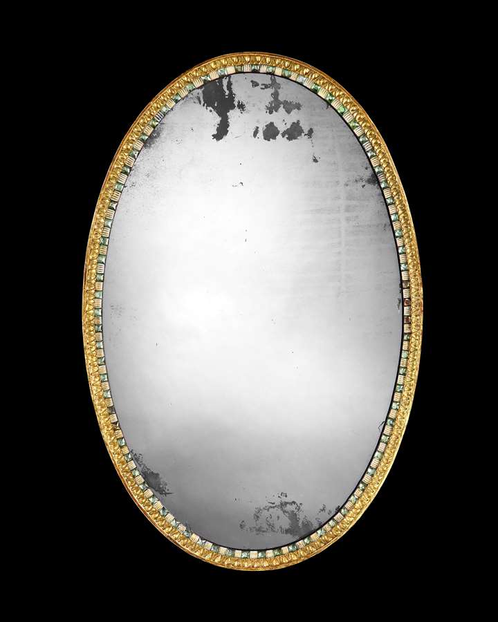 AN IRISH GEORGE III GILTWOOD AND CUT GLASS OVAL MIRROR